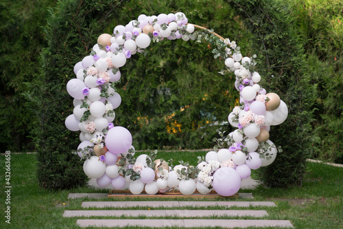 Ouside wedding ceremony. Balloon wedding arch in the garden.