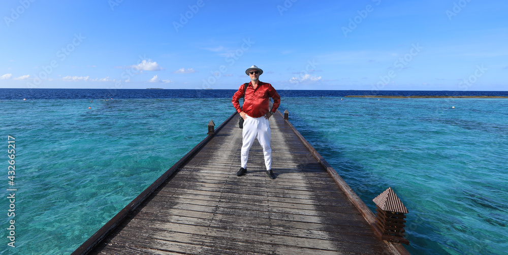 portrait of a man on a pier of a tropical island