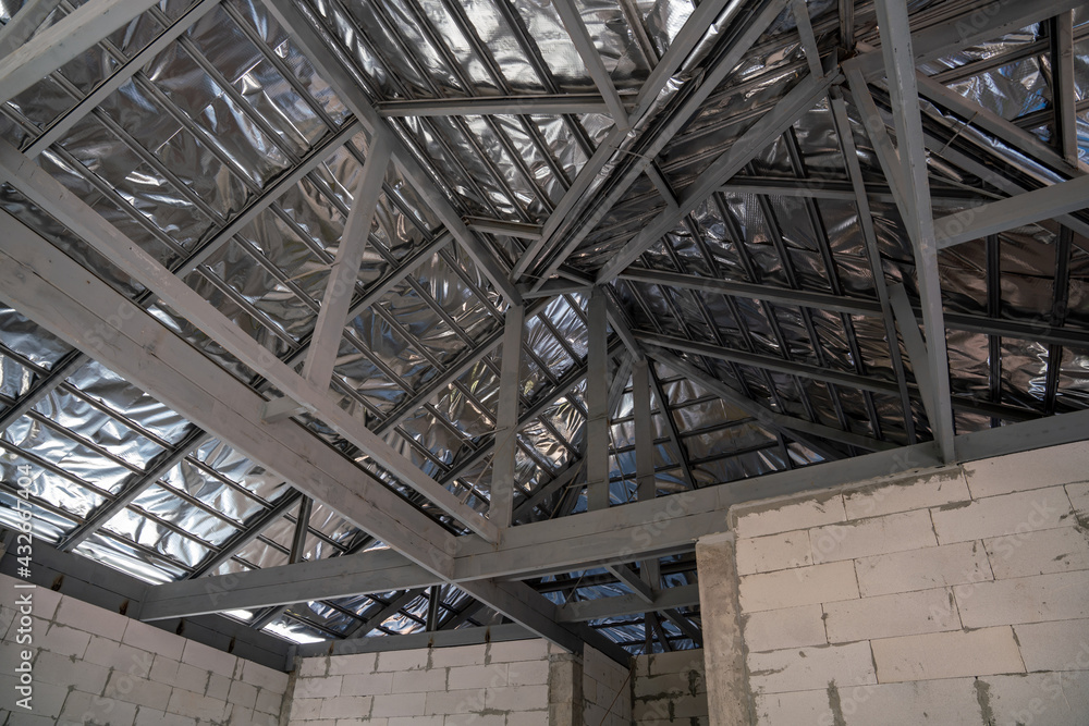 Roof insulation of new tile roof home with spanish tiled roof at unfinished house construction, Under the roof structure Roof insulation of new tile roof home with spanish tiled roof at unfinished house construction, Under the roof structure