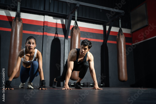Adult Asian women push up and warm up with men personal trainer before boxer training class, Sport, fitness and exercise concept for good health and strong muscle and body.