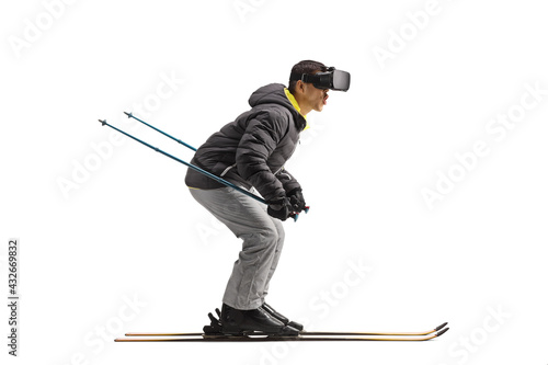 Full length profile shot of a man skiing with VR headset