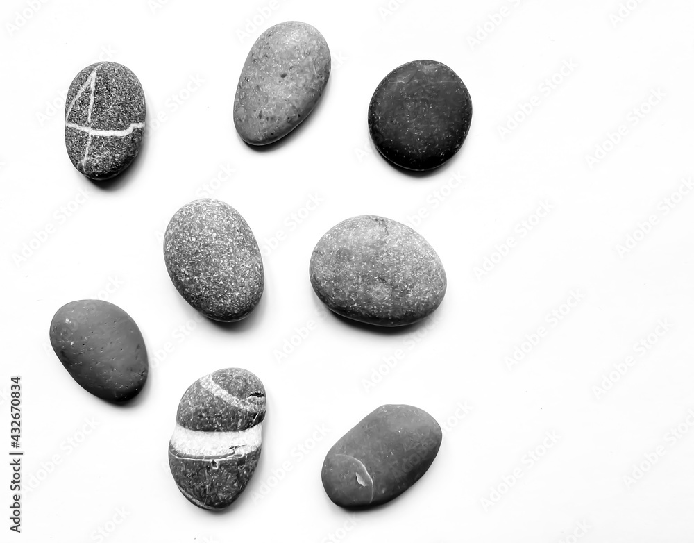 Set of various black-white and gray sea stones. Isolated over white background. Flat lay, top view. Set of various black-white and gray sea stones. Isolated over white background. Flat lay, top view.