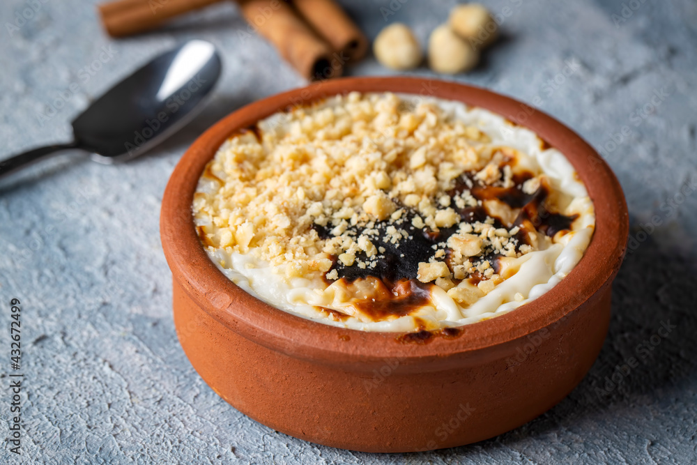 Baked rice pudding turkish milky dessert sutlac in earthenware casserole with hazelnuts Baked rice pudding turkish milky dessert sutlac in earthenware casserole with hazelnuts