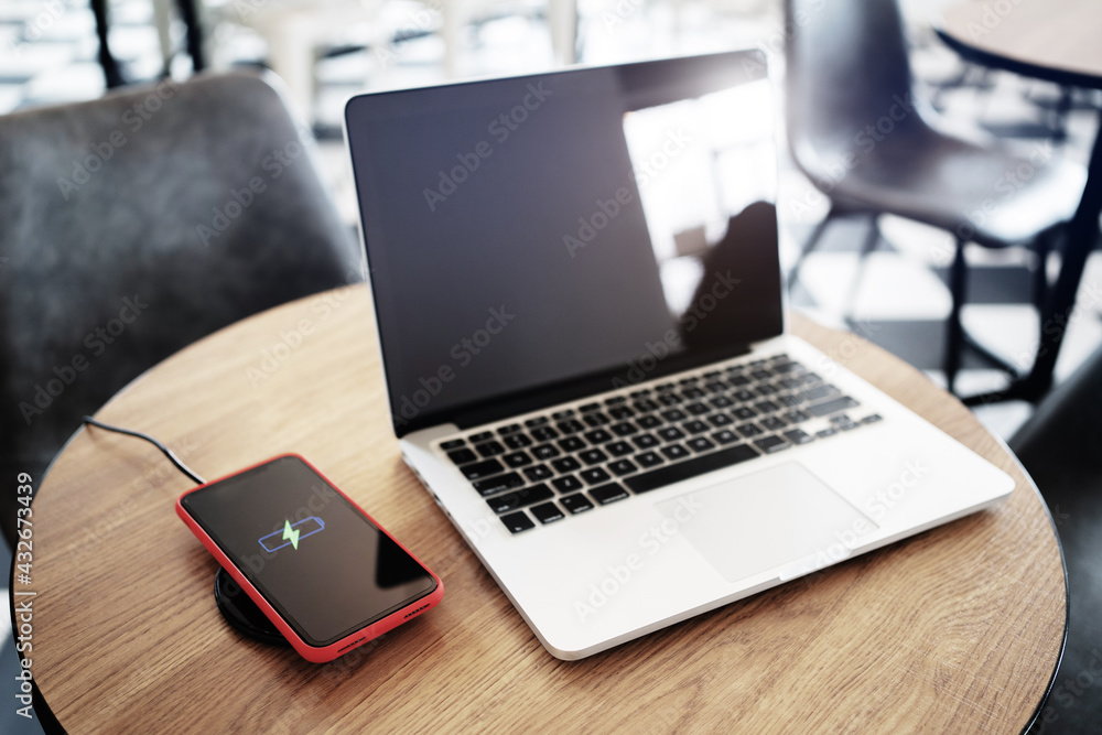 Wireless charger concept, smartphone with charging pad in modern office.. Wireless charger concept, smartphone with charging pad in modern office..