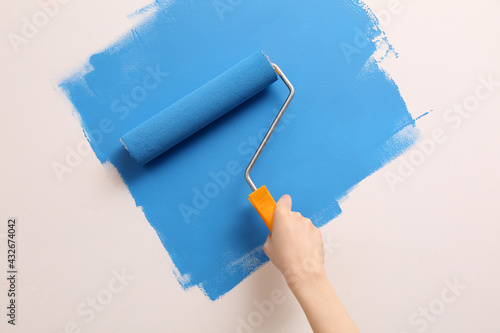 Foto Woman painting wall with roller, closeup. Redecoration
