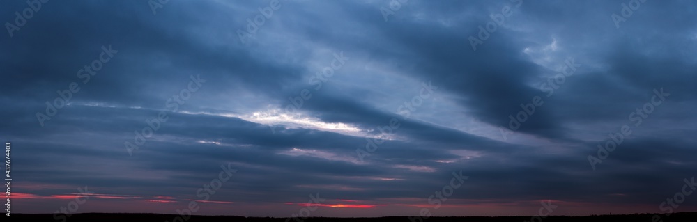 Dark sunset with gloomy clouds and red light on the horizon Dark sunset with gloomy clouds and red light on the horizon