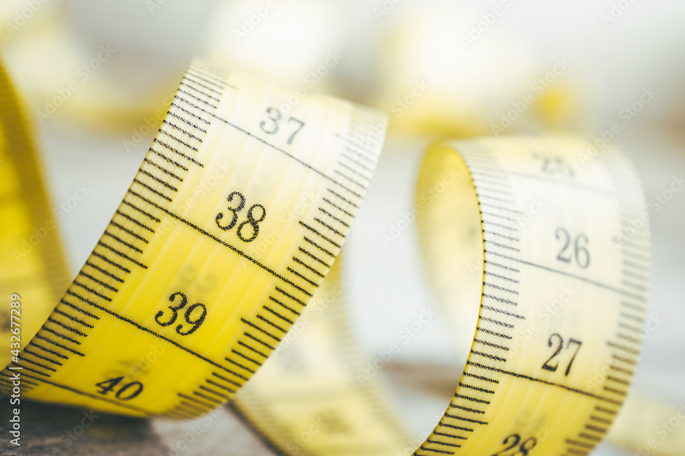 Soft Yellow Measuring Tape in Spiral Shape On A Table Soft Yellow Measuring Tape in Spiral Shape On A Table