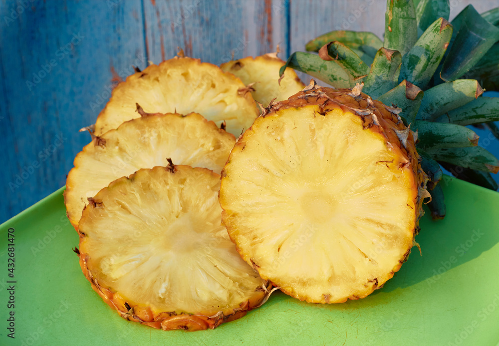 closeup of juicy ripe pineapple (ananas comosus) with sliced pieces. closeup of juicy ripe pineapple (ananas comosus) with sliced pieces.