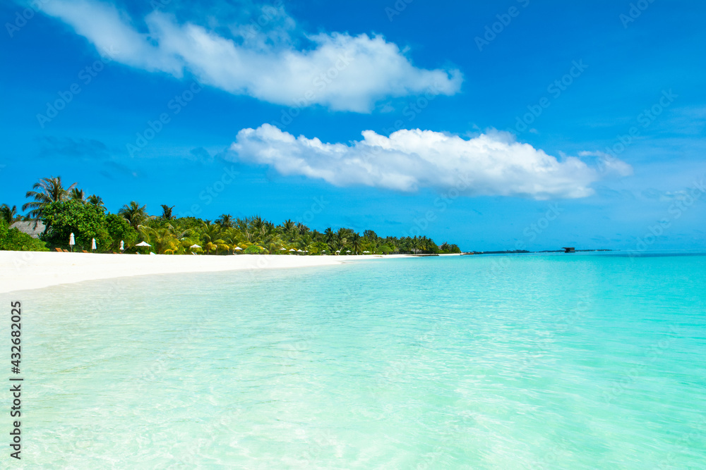 Beautiful sandy beach with sunbeds and umbrellas in Indian ocean, Maldives island