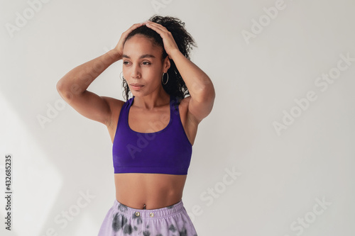 attractive black african american woman in stylish hipster fitness outfit on isolated background