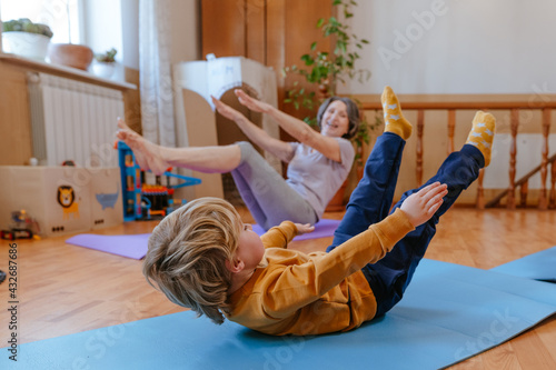 Little 3 years old boy doing exercises with his grandmother