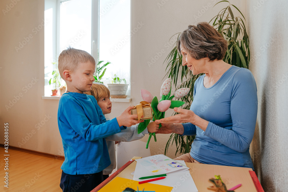 Grandchildren presenting to their grandmother a handmade drawing postcard Grandchildren presenting to their grandmother a handmade drawing postcard