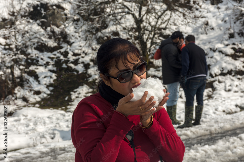 Tourist trying to eat snow just after snowfall.