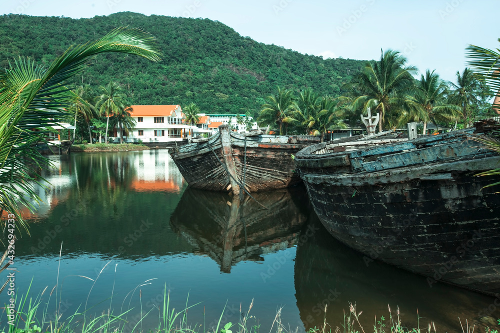 A lake with abandoned old sea boats in the Thai jungle.