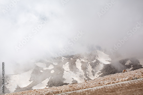 Snowy mountain peaks surrounded with clouds