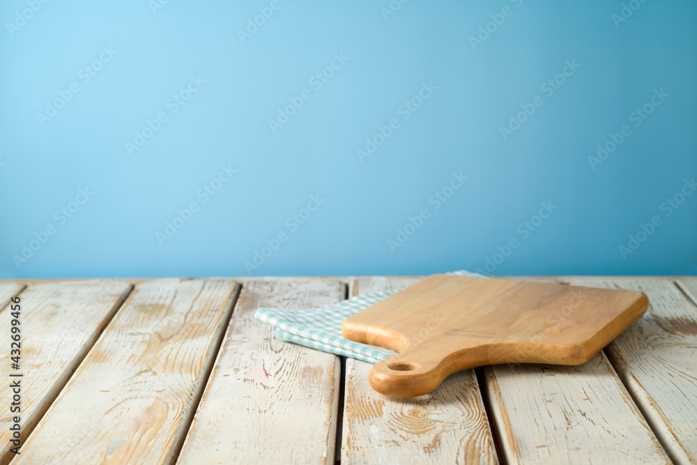 Empty wooden table with tablecloth and cutting board over blue wall  background. Kitchen mock up for design and product display. Stock Photo |  Adobe Stock