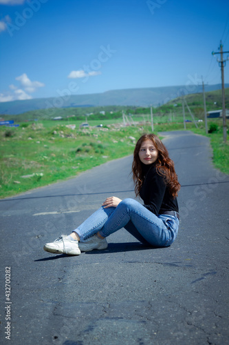 pretty woman sitting on the road, red haired girl sitting on the road