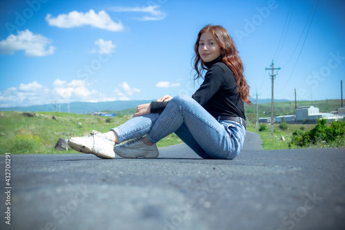 pretty woman sitting on the road, red haired girl sitting on the road