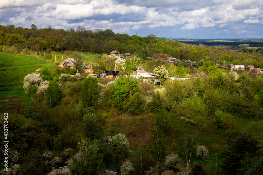 Ukrainian village, spring hills, houses and forest