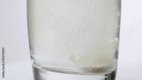 an effervescent tablet in a water glass