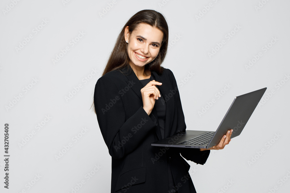 Portrait of young modern happy business woman in classic suit. Attractive female business leader in smart casual wear using laptop computer. Portrait of young modern happy business woman in classic suit. Attractive female business leader in smart casual wear using laptop computer.