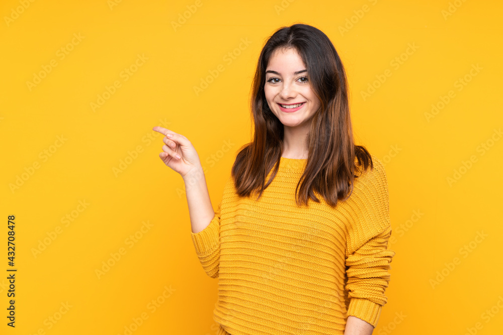 Young caucasian woman isolated on yellow background pointing finger to the side Young caucasian woman isolated on yellow background pointing finger to the side