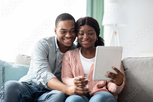 Relaxed african american family using digital tablet together, taking selfie