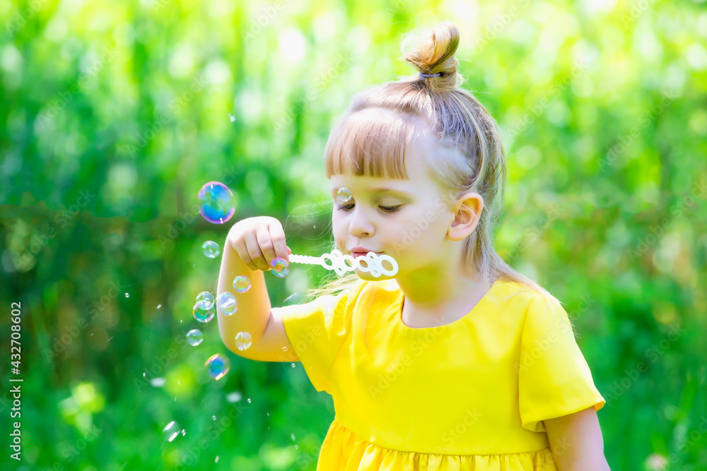 Little girl blows soap bubbles