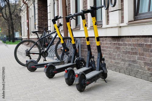 Scooters and bicycles in a parking lot in the city. The concept of modern transport