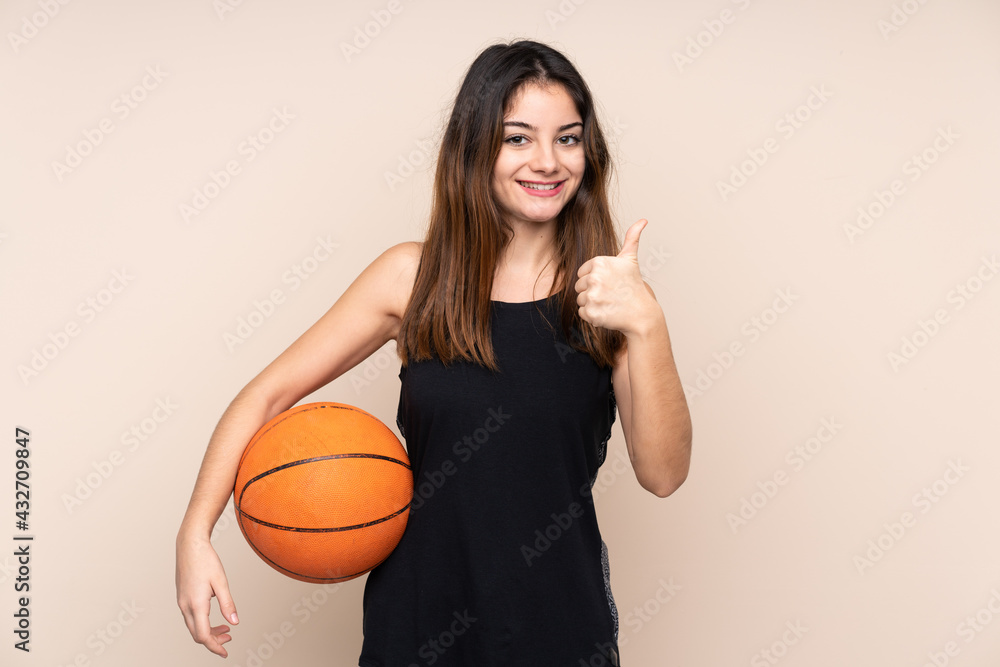 Young caucasian woman isolated on beige background playing basketball and with thumb up