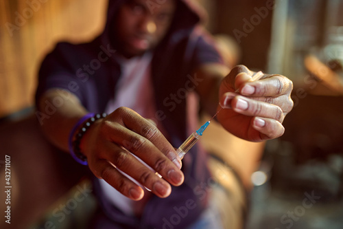 Drug addict man holds syringe with dose