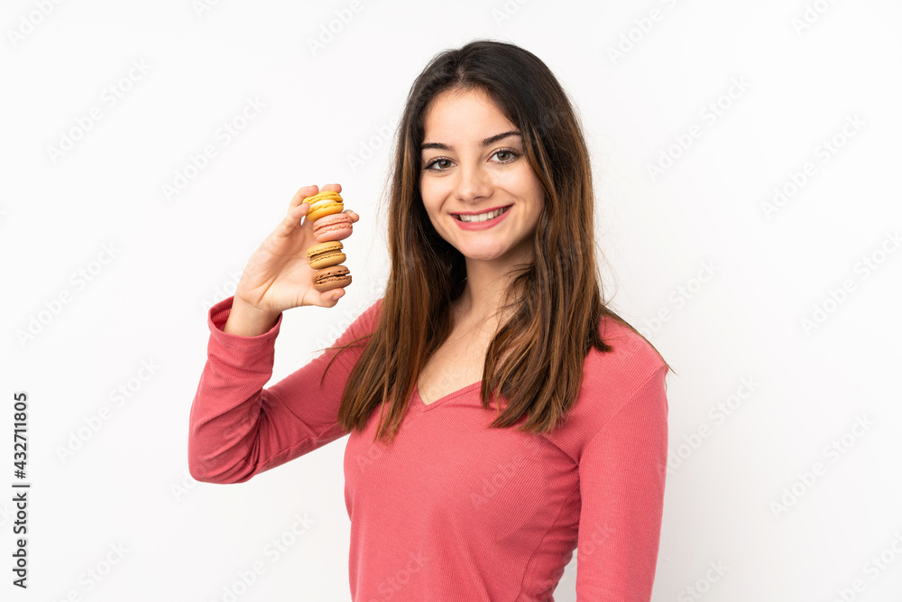 Young caucasian woman isolated on pink background holding colorful French macarons and smiling a lot Young caucasian woman isolated on pink background holding colorful French macarons and smiling a lot