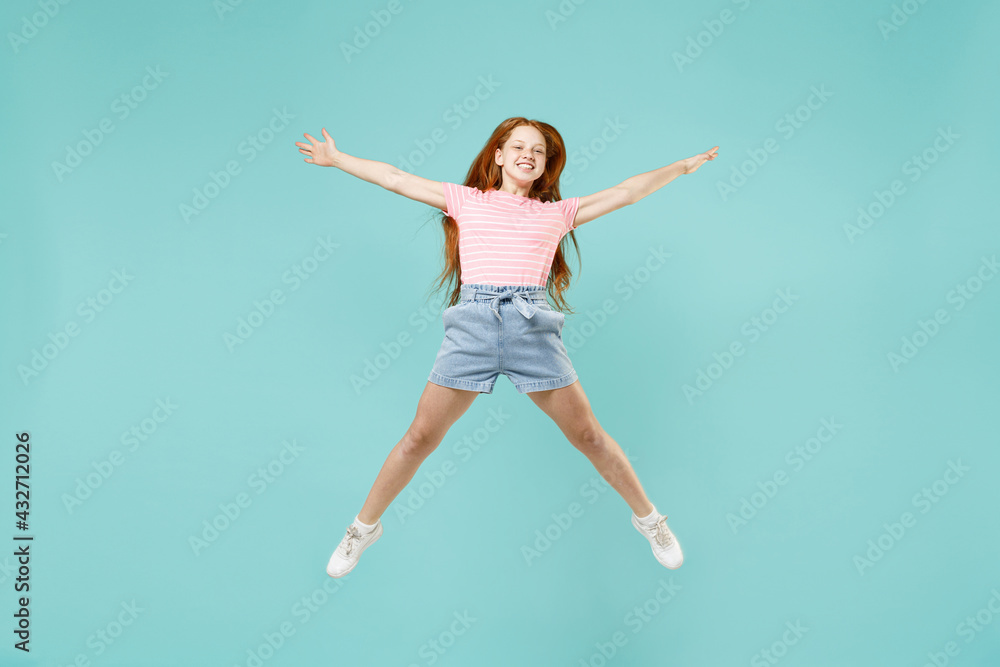 Full length little fun overjoyed happy redhead kid girl 12-13 year old in pink striped t-shirt with outstretched hands isolated on pastel blue background studio Children lifestyle childhood concept. Full length little fun overjoyed happy redhead kid girl 12-13 year old in pink striped t-shirt with outstretched hands isolated on pastel blue background studio Children lifestyle childhood concept.