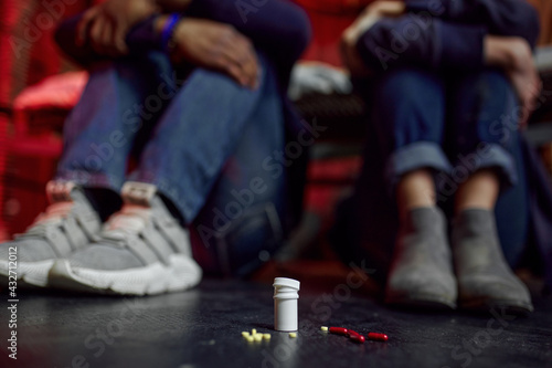 Drug addicts sitting on the floor in den