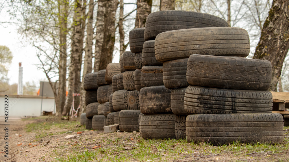 folded old car tires lie on the ground near the road, background folded old car tires lie on the ground near the road, background
