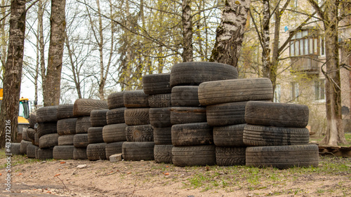 folded old car tires lie on the ground near the road, background © Mihail