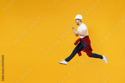Full length young employee handyman man in t-shirt point index finger aside area mock up workspace copy space isolated on yellow background Instruments accessories apartment room. Repair home concept.