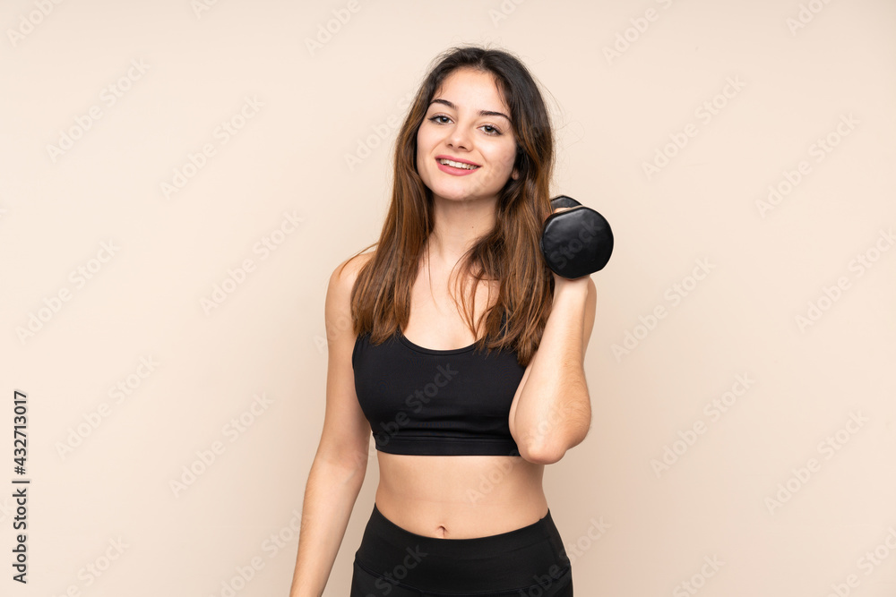 Young sport woman making weightlifting isolated on beige background Young sport woman making weightlifting isolated on beige background