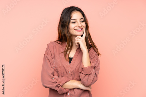 Young caucasian woman isolated on pink background thinking an idea while looking up © luismolinero