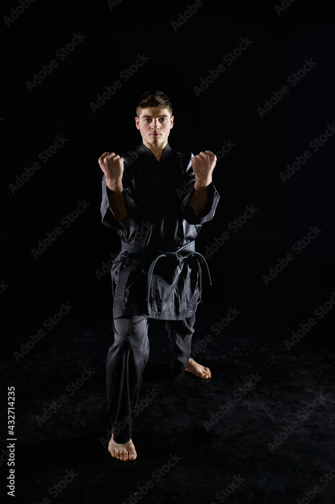 Male karate fighter in black kimono, front view