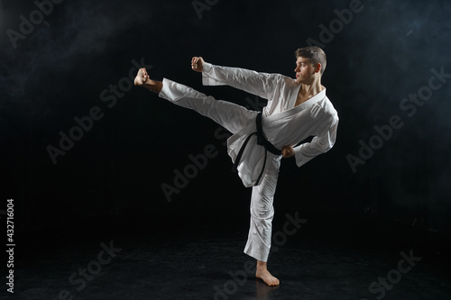 Male karateka, fighter in black kimono, training © Nomad_Soul