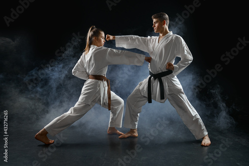 Female karate fighter on training with master