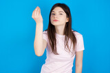 young beautiful Caucasian woman wearing stripped T-shirt over blue wall Doing Italian gesture with hand and fingers confident expression