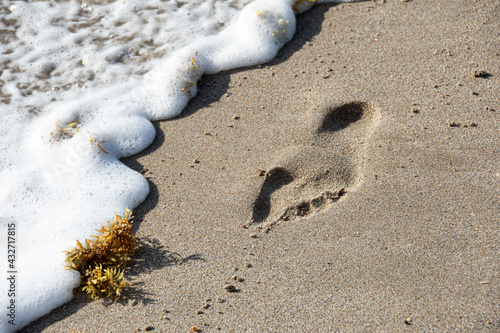 Surf washing away footprints in sand