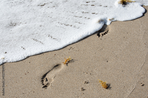 Surf washing away footprints in sand