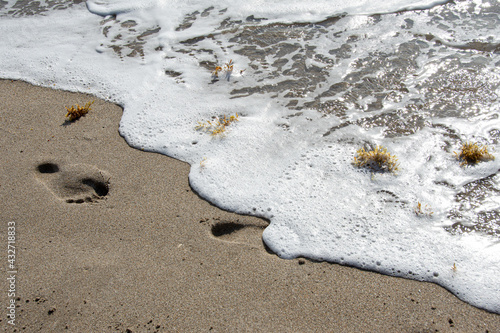 Surf washing away footprints in sand