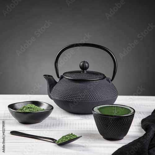 Matcha tea powder and tea accessories on light base on gray background with copyspace.. Tea ceremony. Traditional japanese drink
