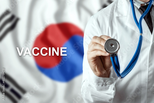 Close-up of a doctor and the word vaccine on the background of the flag of South Korea. Corona virus vaccine production. Pandemic, isolation, 3rd wave, epidemics.