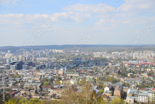 LVIV, UKRAINE - APRIL 17, 2019: People tourists at the top of High Castle Hill, Ukrainian city old town mountain peak on sunny summer day cityscape. Lviv city seen from mount on High Castle Hill © Moonhonor