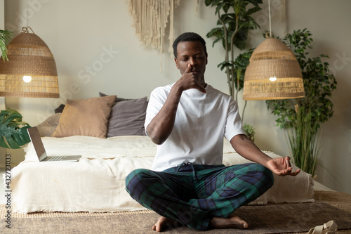 Photography Young african man practicing yoga lesson, doing Alternate Nostril Breathing exer